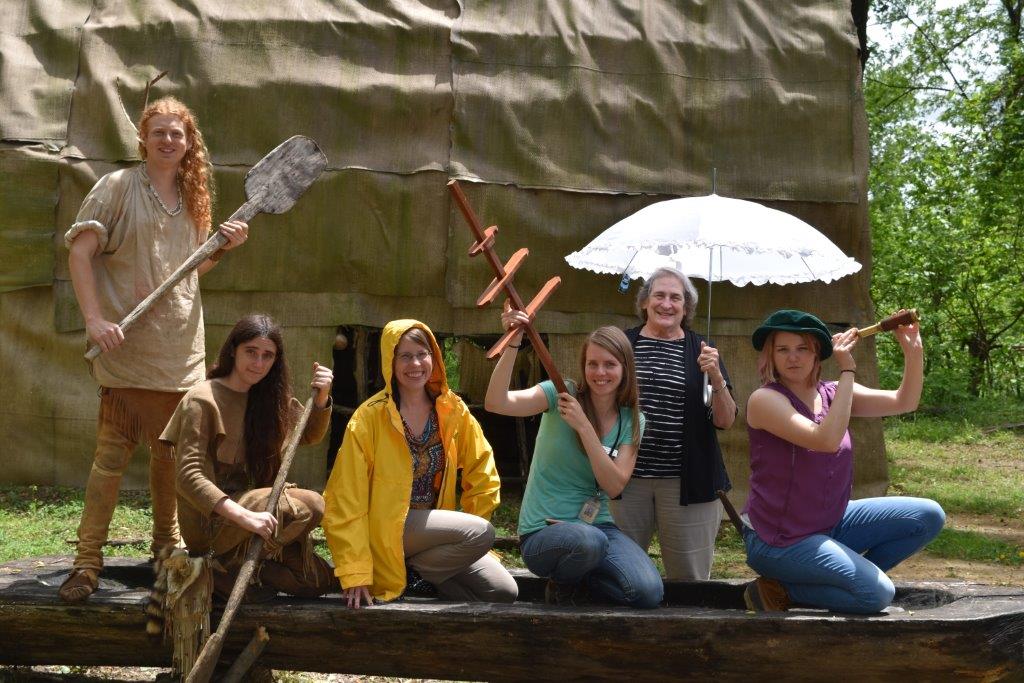 Education Staff Posing on Canoe with Objects