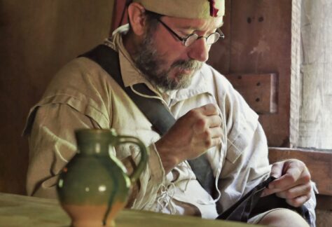 Colonial man sewing